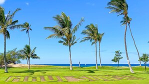 A golf course with palm trees and a clear blue sky.