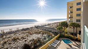 A beach view from a hotel balcony with a swimming pool and lounge chairs. - PI 406: Sunset Shores - Take A Look! Perfect Beach Retreat with Beach Service (Fort Walton Beach)