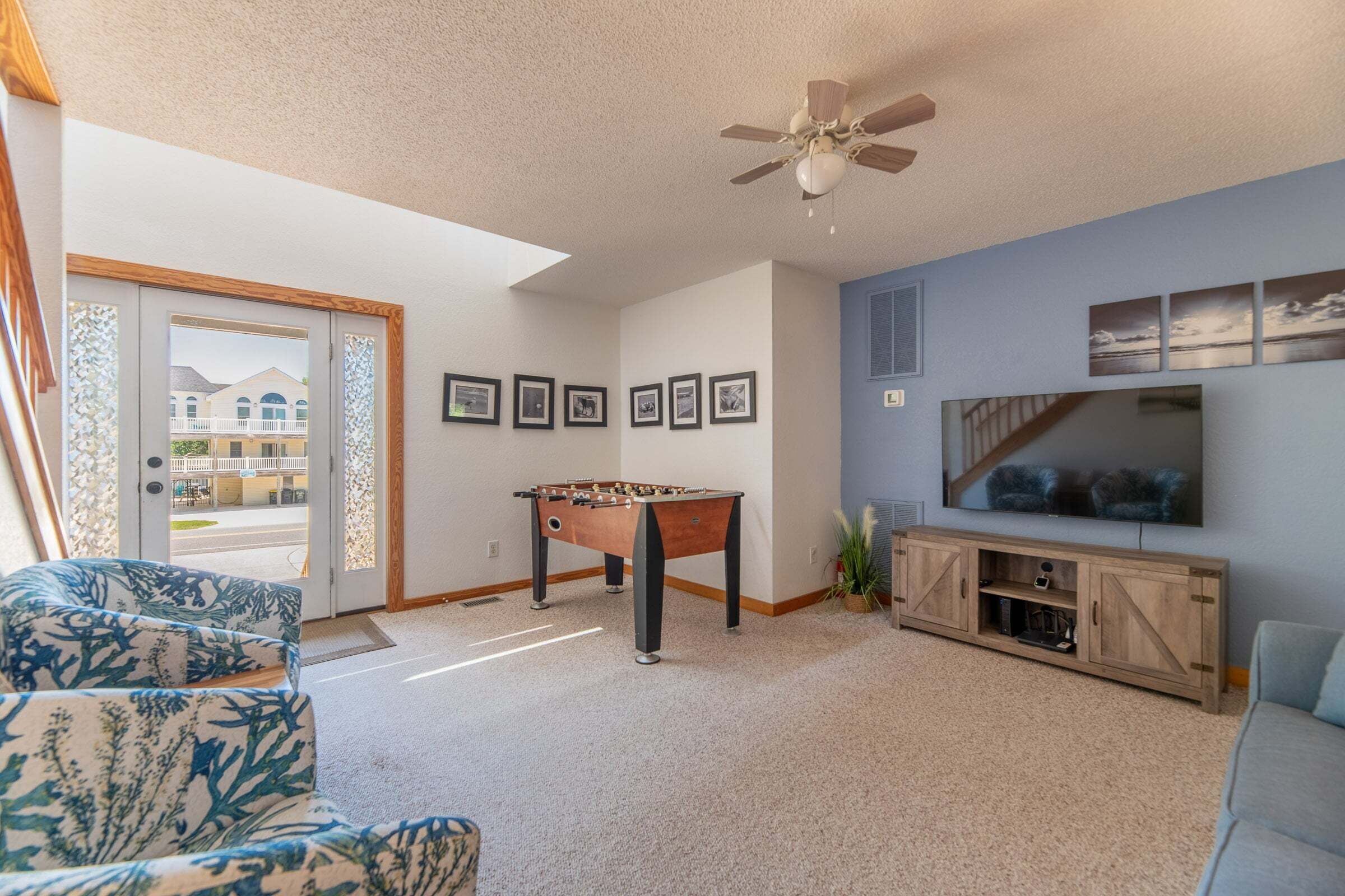 A living room with a foosball table, a television, and a sofa.