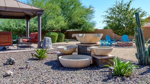 A patio area with outdoor furniture, a pergola, and decorative planters.