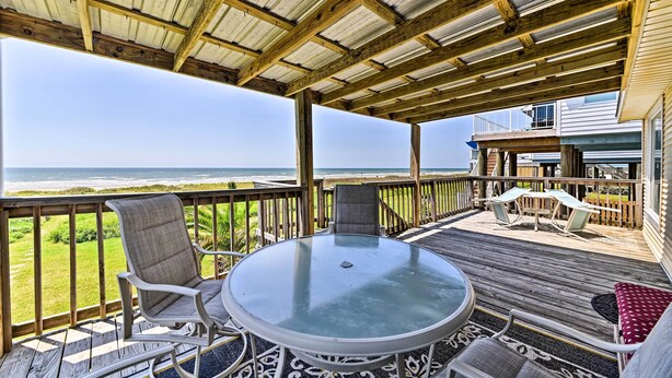A covered outdoor deck with a glass table and chairs, overlooking the ocean. - Steps to Gulf! Pet-Friendly Galveston Getaway (Galveston)