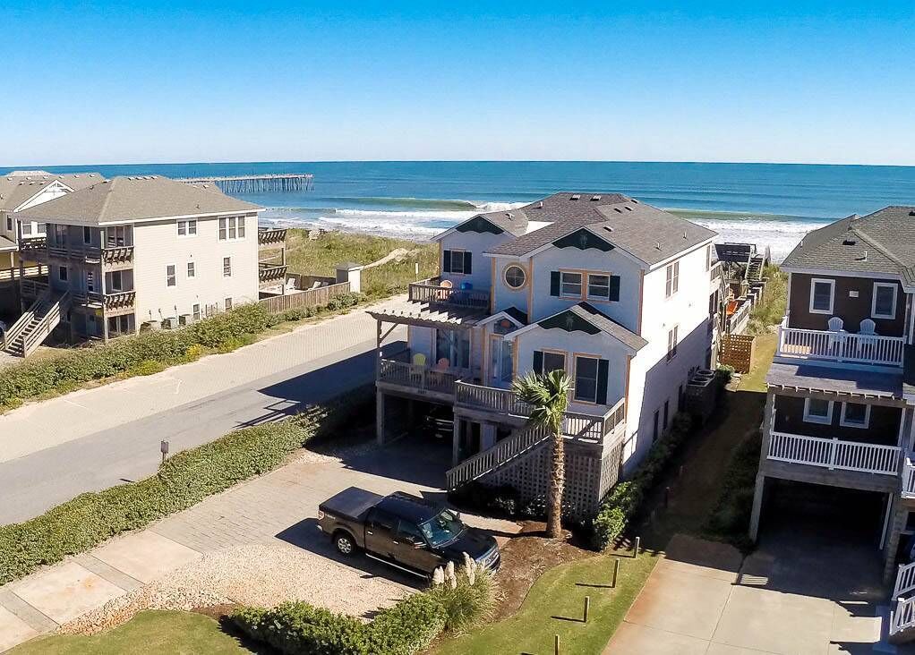 Une zone résidentielle côtière comprenant des maisons, une plage et une jetée.