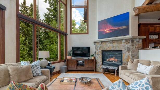 Un salón amplio con chimenea, ventanas grandes y televisor.