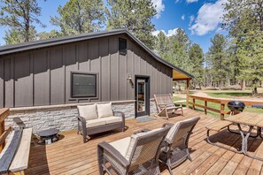 A wooden deck with outdoor furniture, a barbecue grill, and a stone wall. - Private Black Hills Home w/ Corral: Horses Welcome (Custer)