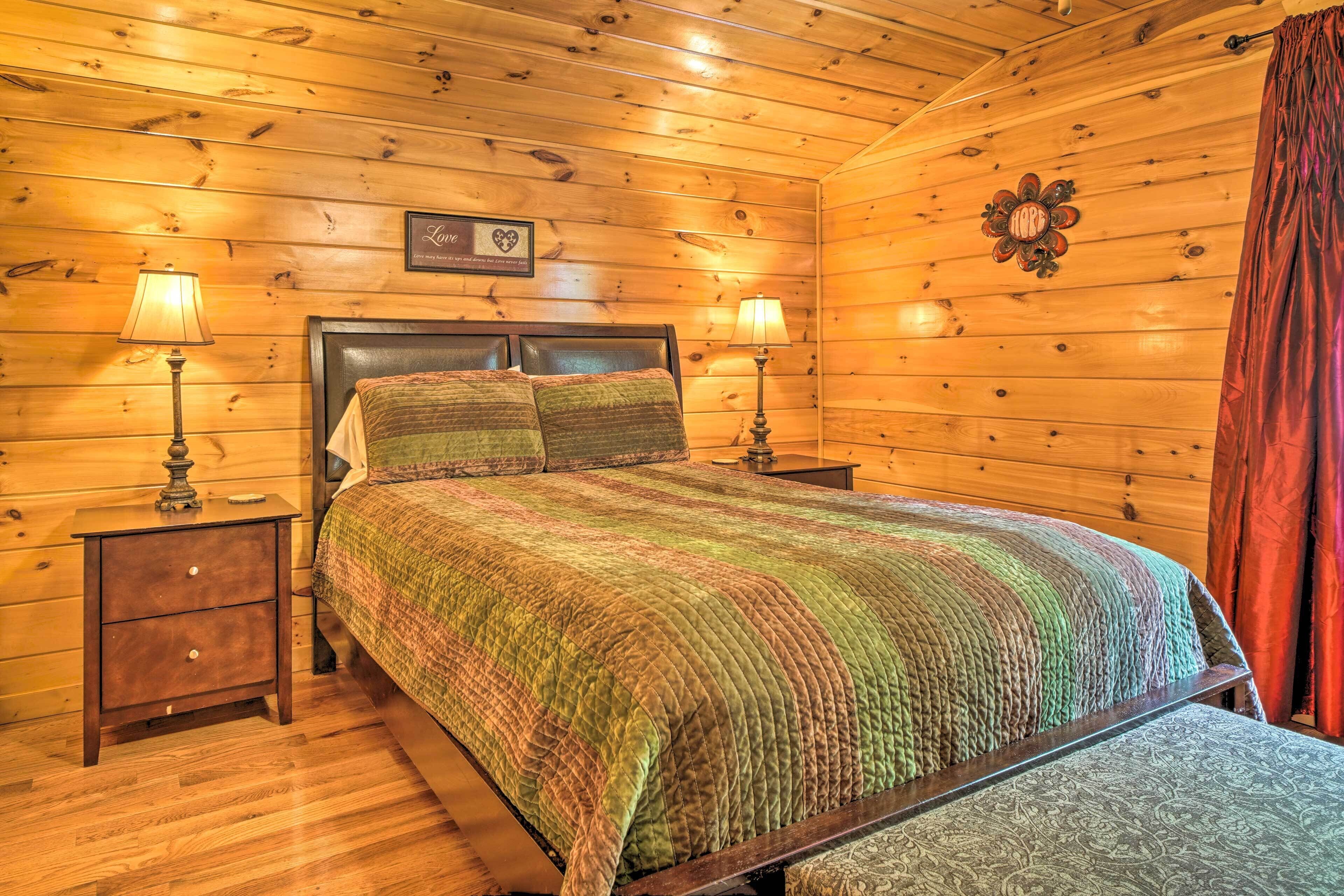 A wooden-paneled bedroom with a bed, two bedside tables, and a wall-mounted lamp.