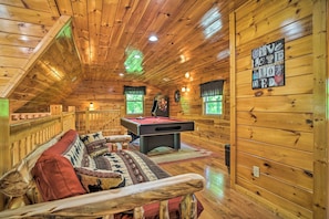 Relax in a warm and inviting space with a pool table and comfortable seating area.