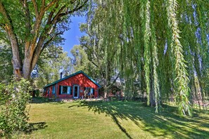 A red building with a blue roof, surrounded by lush greenery and trees. - Quiet Durango Farmhouse w/ Beautiful Yard & Gazebo (Durango)