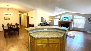 Amplia sala de estar con isla de cocina, mesa de comedor y asientos.