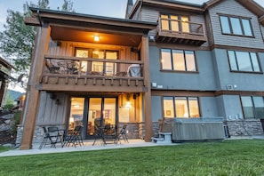 A two-story house with a balcony, outdoor seating, and a barbecue area.
