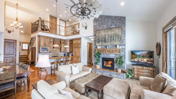 A spacious living room with a fireplace, a dining area, and a kitchen.