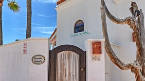 A white building with a sign reading "Casa de Por" and a number "46".