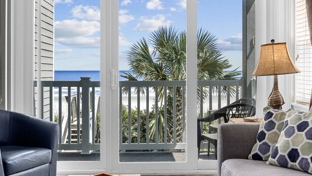 A balcony with a view of the beach, a chair, a table, and a lamp. - *Fall into Savings-20% Off New Bookings thru 2026* (Surfside Beach)