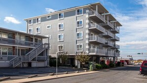 Un hôtel à plusieurs étages doté de balcons, d’un parking et offrant une vue sur un ciel dégagé.