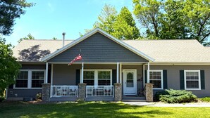 A two-story house with a front porch, a flag, and a mailbox.