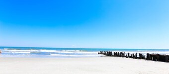 Beobachten Sie Pelikane über dem Strand von der abgeschirmten Veranda dieses erhöhten Strandbungalows.