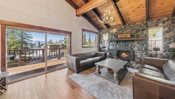 A spacious living area with a stone fireplace, leather sofas, and a wooden ceiling. - Heavenly Mountain View: Pool Table, Hot Tub, BBQ (South Lake Tahoe)