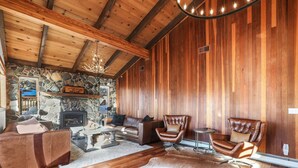 A cozy living room with a stone fireplace, leather furniture, and a wooden ceiling. - Heavenly Mountain View: Pool Table, Hot Tub, BBQ (South Lake Tahoe)