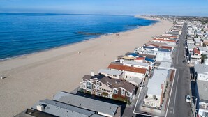 A coastal town with a beach, houses, and a road. - Awesome lower unit in a duplex just one house away from the sand and boardwalk! (Newport Beach)
