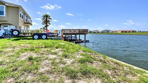 A waterfront property with a house, a dock, and a trailer. - Waterfront Corpus Christi Townhome w/ Pool & Dock! (Corpus Christi)