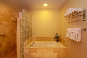 A bathroom with a glass-enclosed shower, a bathtub, and a towel rack with towels. - 3 bed/3 bath Poipu Condo - Central A/C, Walking path to Beach (Koloa)