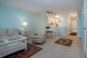 Relax in this stylish living room with a sofa, armchair, and dining area, perfect for socializing and unwinding.