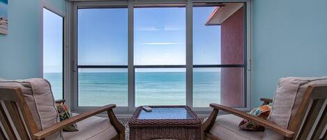 Enjoy ocean views from the room's large window, which is accompanied by a small table and two comfortable chairs.