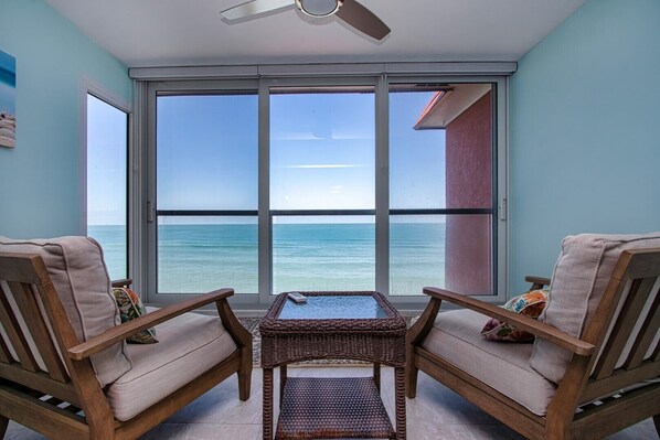 Enjoy ocean views from the room's large window, which is accompanied by a small table and two comfortable chairs.