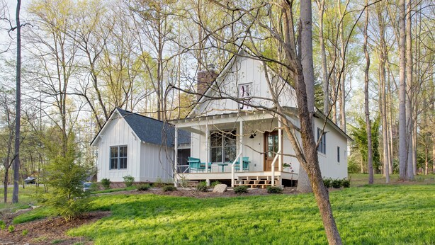 A white house with a porch, surrounded by trees and a grassy yard. - Enchanting Andersonville Home Steps to Norris Lake (Andersonville)