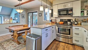 Una cocina moderna con electrodomésticos de acero inoxidable, detalles de madera y una isla grande.