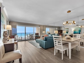 Relax in a spacious living area with a comfortable sofa, dining table, and flat-screen TV, offering a view of the ocean.