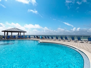 Relax by the serene pool, surrounded by a sheltered seating area with lounge chairs.