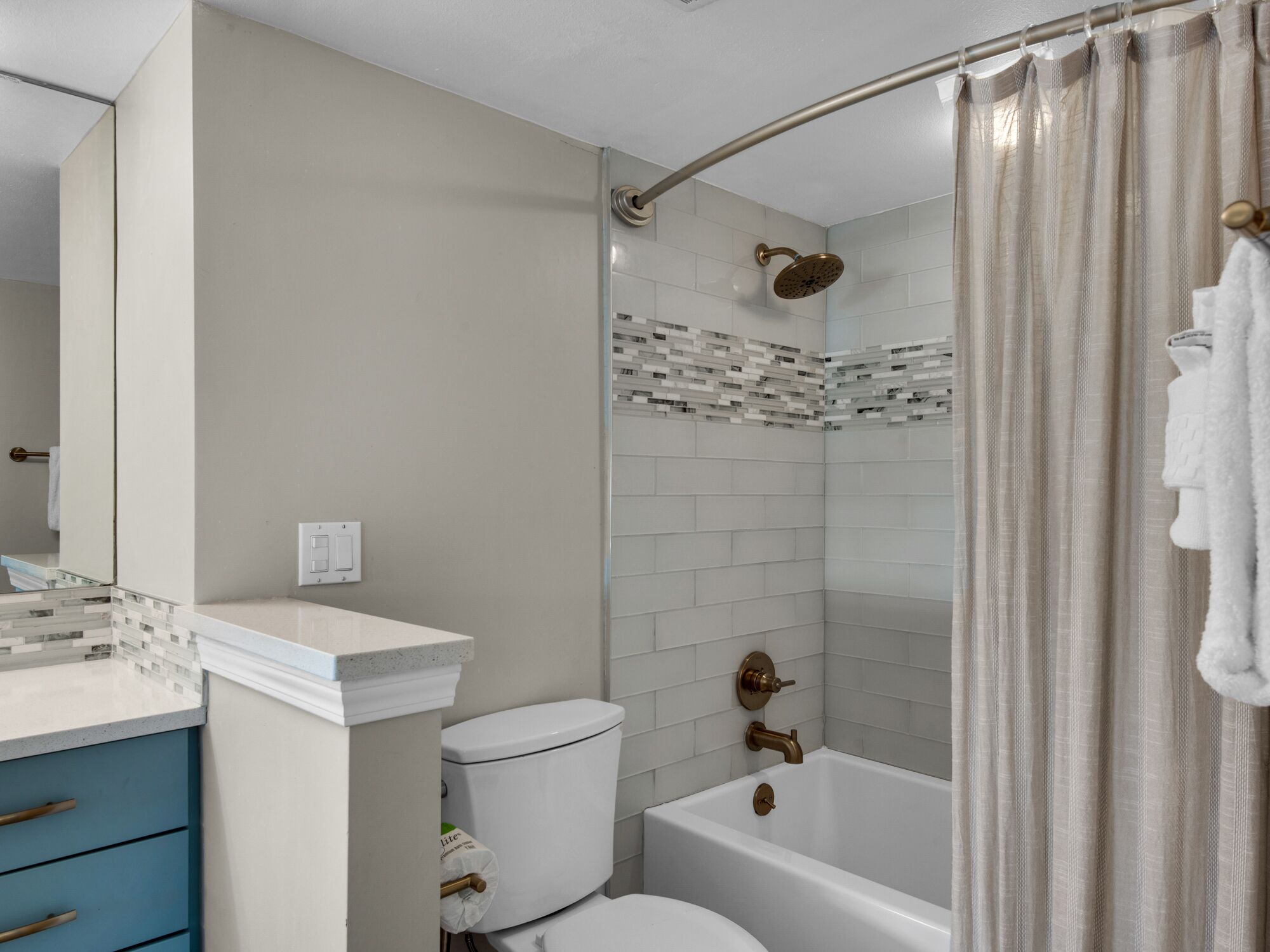 A modern bathroom with a toilet, sink, and bathtub.
