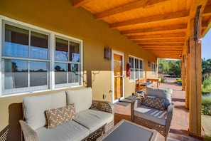 Relax in this inviting outdoor seating area with wicker sofas, a small table, and a chair.