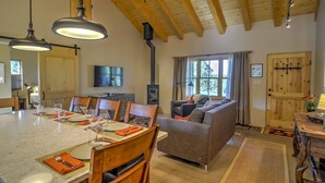 A dining area with a marble table set for four, wooden chairs, and pendant lights. - Hidden Santa Fe Gem - Nestled in Tesuque Hills! (Santa Fe)
