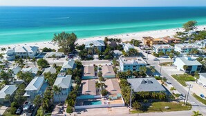 Uma área residencial costeira com casas, uma praia e vista clara do oceano.