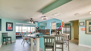 A spacious kitchen with a central island, dining area with chairs, and a view to the living room. - Waterfront Getaway w/ Pool & Dock - Walk to Beach! (Indian Rocks Beach)
