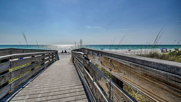 A wooden boardwalk leading to a beach with clear skies and calm waters. - Waterfront Getaway w/ Pool & Dock - Walk to Beach! (Indian Rocks Beach)