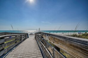 A wooden boardwalk leading to a beach with clear skies and calm waters. - Waterfront Getaway w/ Pool & Dock - Walk to Beach! (Indian Rocks Beach)