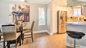 A modern kitchen with stainless steel appliances, a dining area with a glass table, and a ceiling fan. - Pool & Hot Tub Access: Modern Palm Springs Condo (Palm Springs)