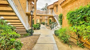 A narrow pathway flanked by buildings with balconies and staircases, leading to a central courtyard. - Pool & Hot Tub Access: Modern Palm Springs Condo (Palm Springs)
