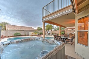 A hot tub in a backyard with a patio and outdoor furniture. - Hot Tub & Pool: Stunning Goodyear Home Near Lakes (Goodyear)