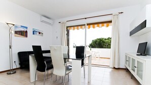Una sala de estar moderna con comedor, televisor y balcón con vistas.