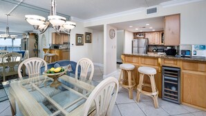 A modern kitchen with wooden cabinets, a stainless steel refrigerator, and a built-in oven.