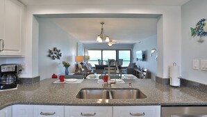 A modern kitchen with granite countertops, stainless steel appliances, and a central island. - Views from Beachfront Balcony ~ Pool ~ Updated    Fantastic Location Near Shops Bars and Restaurants (Madeira Beach)