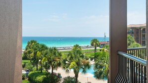 Ein Balkon mit Blick auf Strand, Pool und Hotelgebäude.