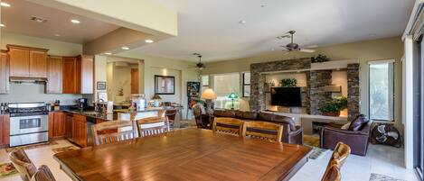 A spacious kitchen with wooden cabinets, a large dining table, and a built-in fireplace.