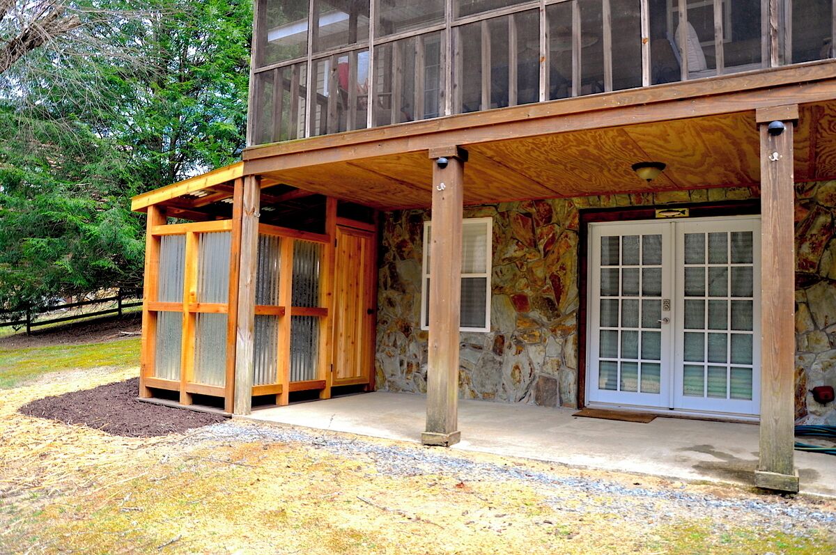 A two-story building with a covered porch and a stone facade.