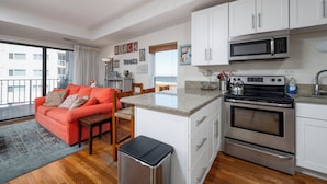 Un espacio habitable compacto con kitchenette, comedor y sofá.