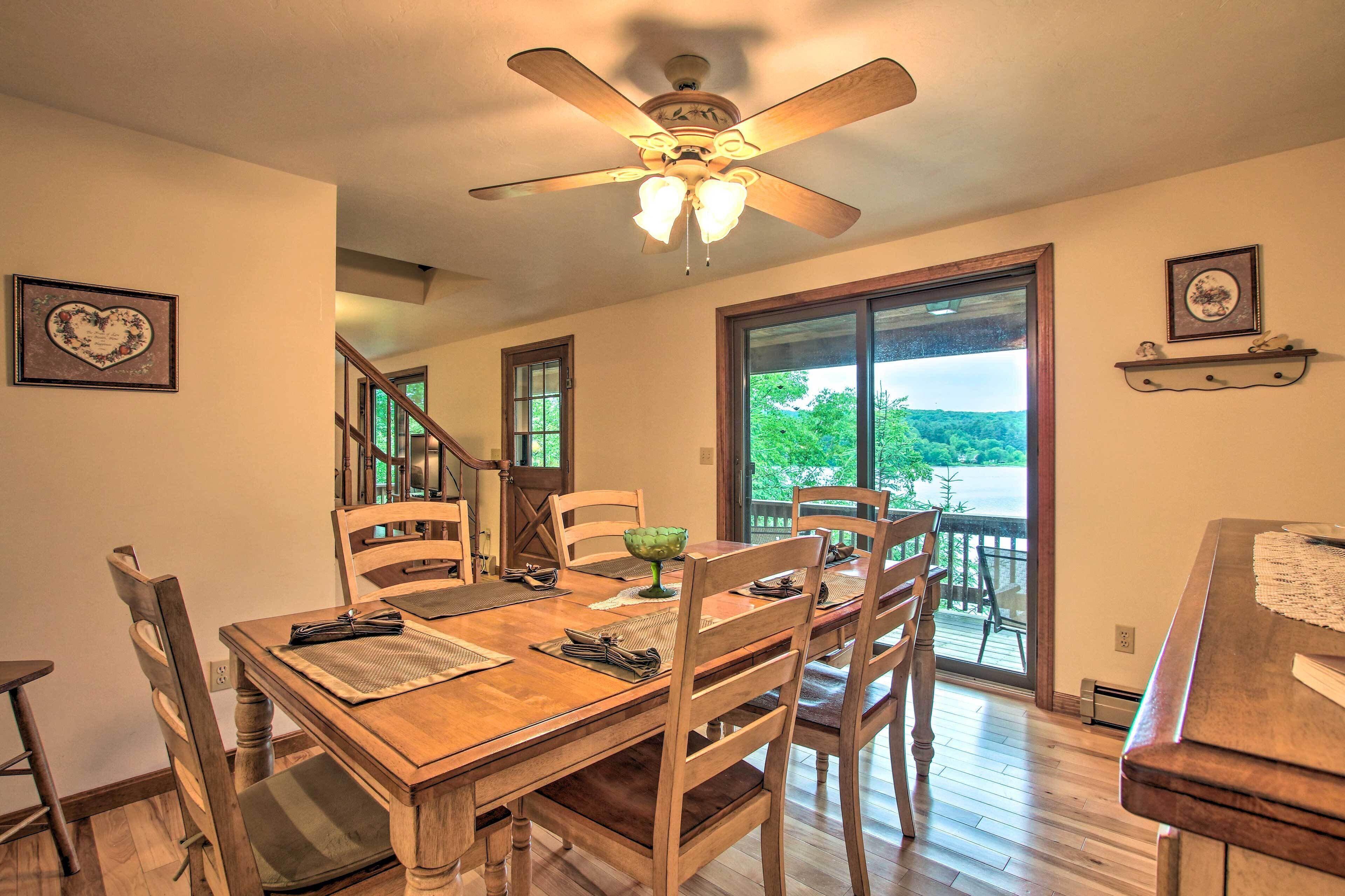 A dining area with a wooden table, chairs, and a ceiling fan.