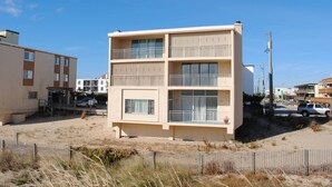 Un immeuble à plusieurs étages doté de balcons, situé près d’une plage.